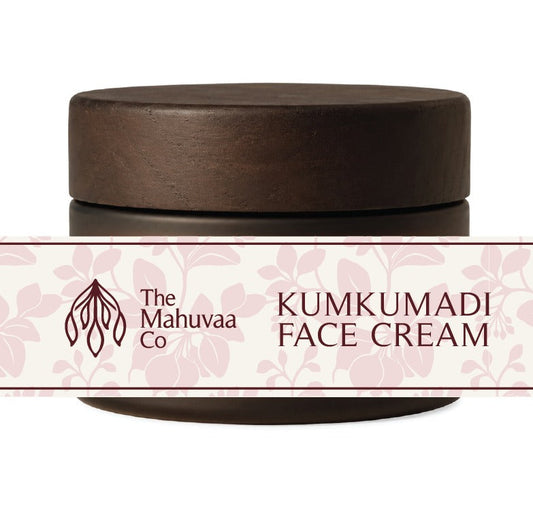 A jar of The Mahuvaa Co Kumkumadi Face Cream with a dark brown wooden lid and a white label featuring pink floral patterns and brown text, set against a plain white background.